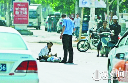 女孩從摩的上摔下，跌坐路中央，恰遇社區(qū)聯(lián)防巡邏人員扶起。