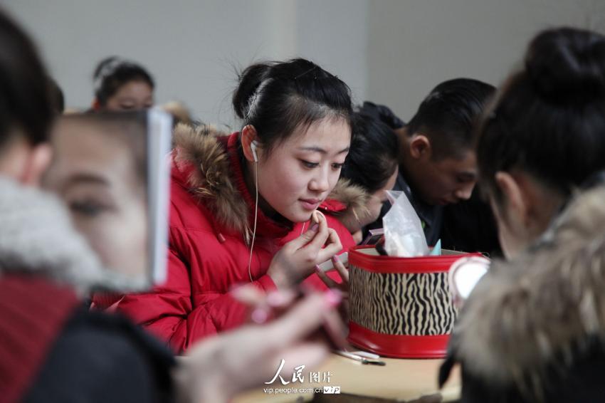 2014年2月17日，山東濱州，藝考候考考生在濱州學院報名點化妝。