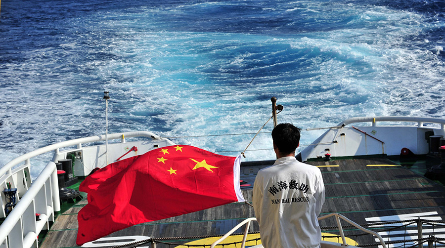 3月18日，水手李國(guó)棟在南海救101輪船甲板后部升起國(guó)旗。新華社記者 趙穎全攝